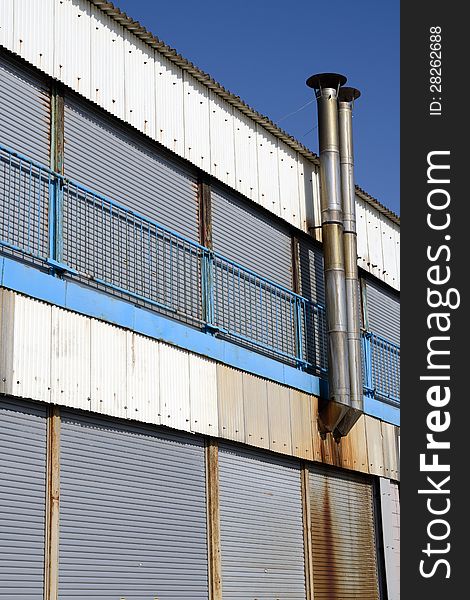 Old rusty refinery exterior against blue sky