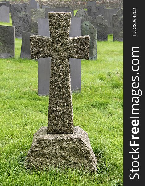 A Granite Stone Cross Standing in a Cemetery. A Granite Stone Cross Standing in a Cemetery.