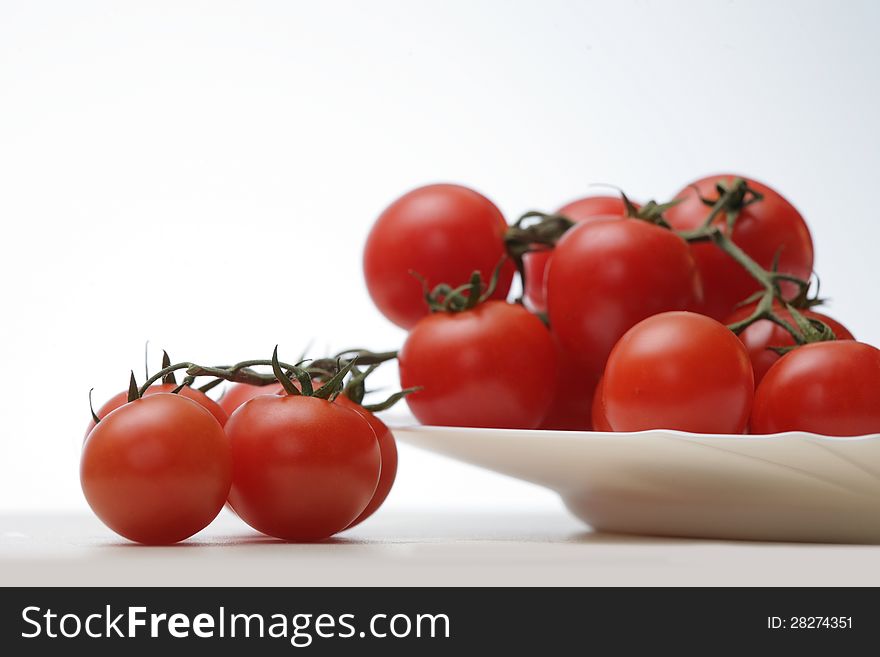 Tomatoes in a white plate on white background