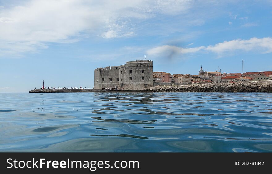 fortress on coast with renesance town in background