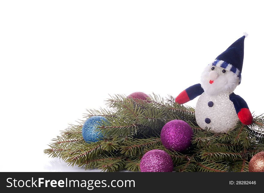 Colorful balls and snowman lying on spruce branches. background