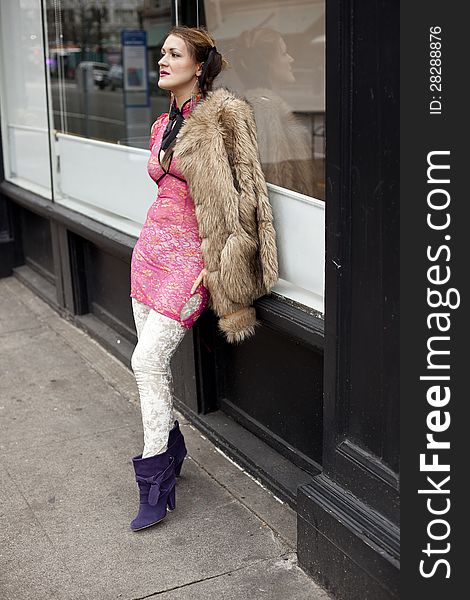 Young womanwith pink top and fur coat on the street. Young womanwith pink top and fur coat on the street.