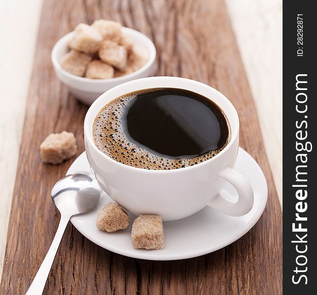 Cup of coffee with brown sugar on a wooden table. Cup of coffee with brown sugar on a wooden table.