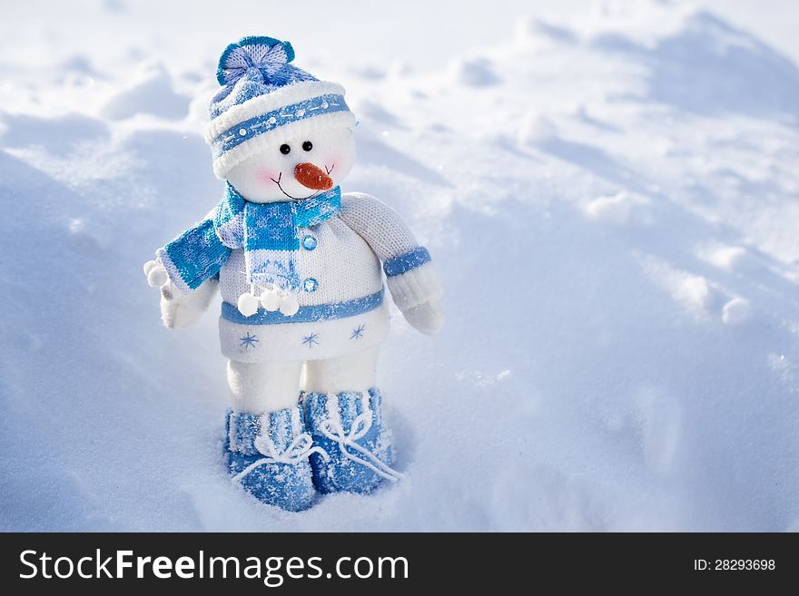 Toy snowman on a snowy background. Toy snowman on a snowy background.