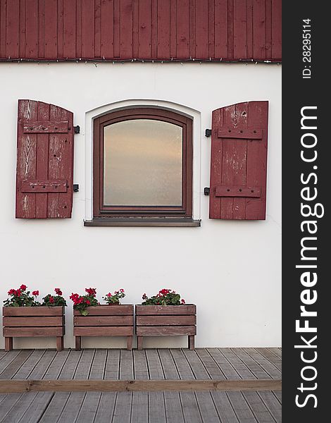 Red shutters on a white wall of an old house. Red shutters on a white wall of an old house