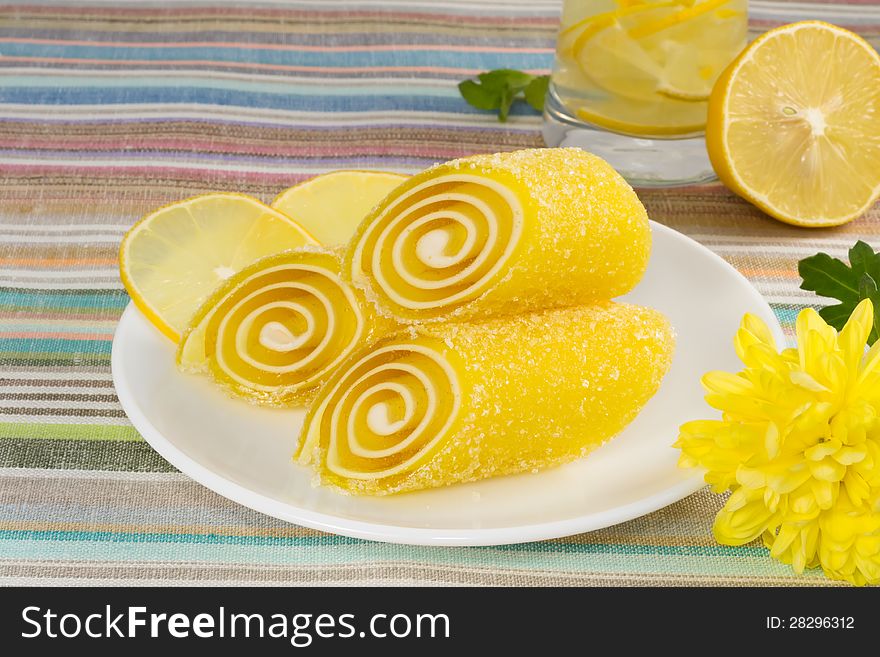 Yellow Candy Fruit On A Plate With Lemon And Flower