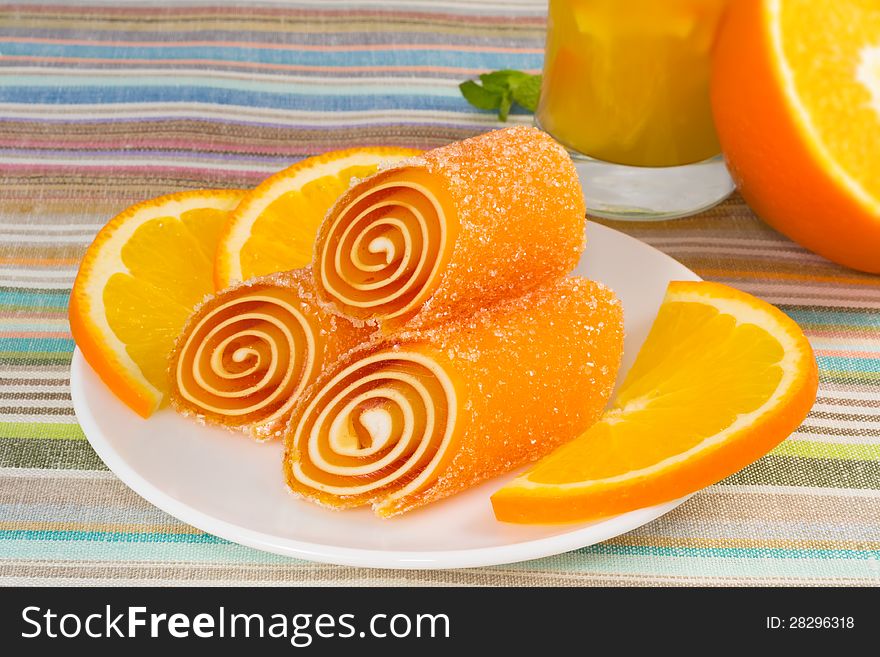 Candy fruit on a plate with orange, closeup
