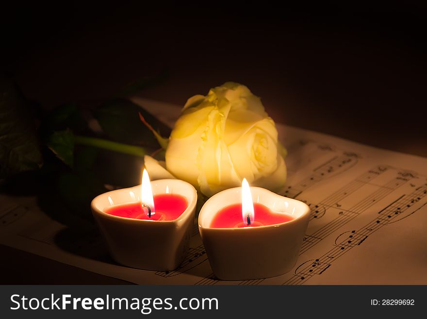 Beautiful rose, and two candles in the shape of heart. Beautiful rose, and two candles in the shape of heart