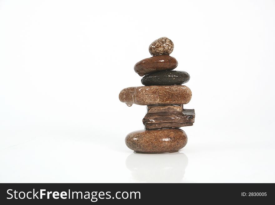 Six stones balancing on a white background