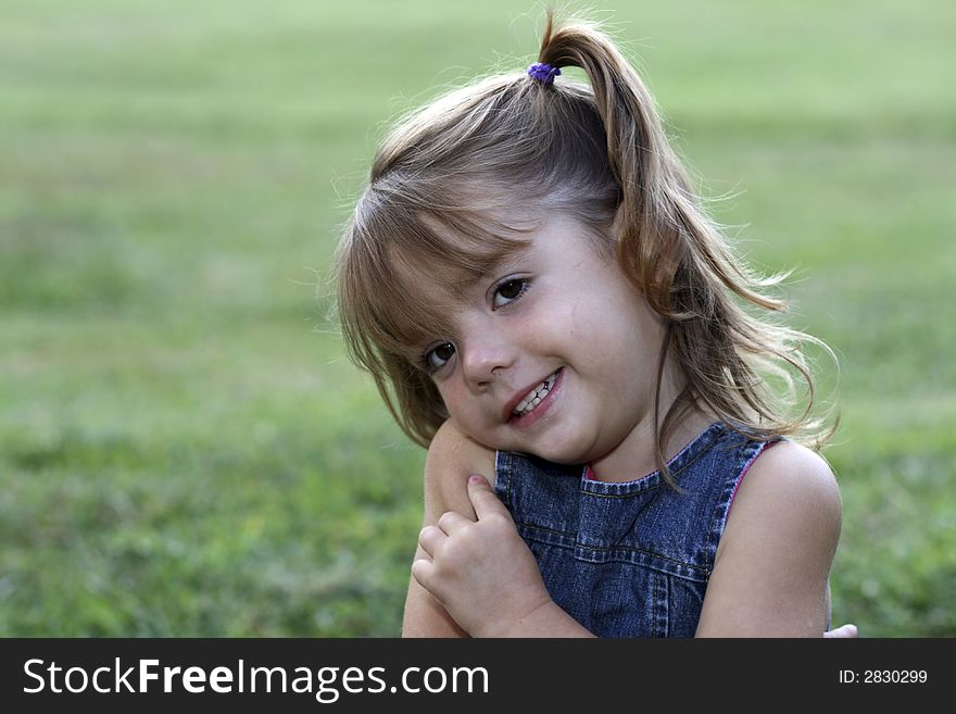Young girl with big smile in grass. Young girl with big smile in grass