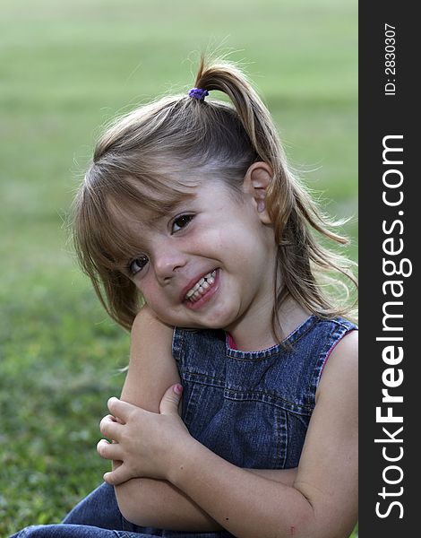 Young girl with big smile in grass. Young girl with big smile in grass