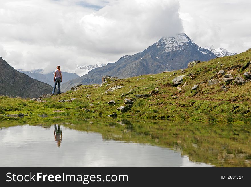 Young woman hiker having a rest after long walk in mountains. Young woman hiker having a rest after long walk in mountains