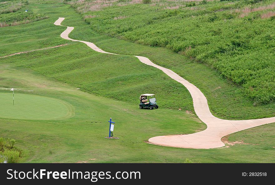 A golf cart path on a course descending into the distance