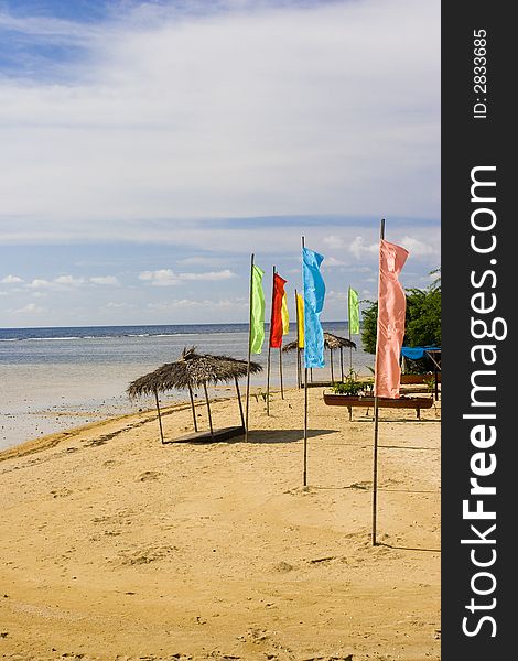 A few flags and a beach hut on the shore. A few flags and a beach hut on the shore