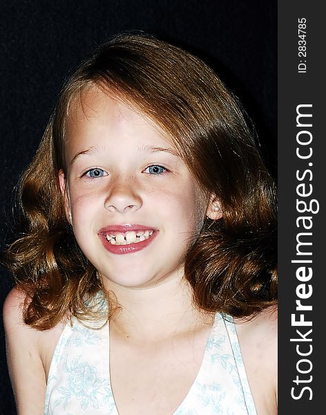 Pretty little young blue eyed girl with reddish brown hair and a big smile posing for a photo. Pretty little young blue eyed girl with reddish brown hair and a big smile posing for a photo.