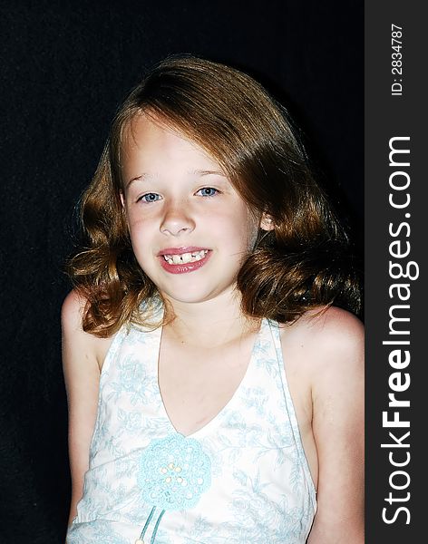 Pretty little young blue eyed girl with reddish brown hair and a big smile posing for a photo. Pretty little young blue eyed girl with reddish brown hair and a big smile posing for a photo.