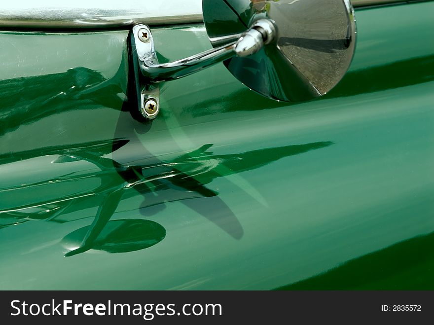 Oldtimer detail of an old green Pontiac. Chrome-plated mirror. Oldtimer detail of an old green Pontiac. Chrome-plated mirror