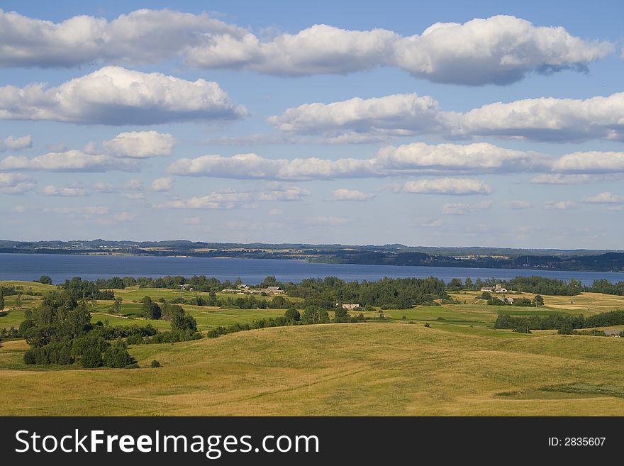 Landscape of fields and lake with clouds, captured in Latvia. Landscape of fields and lake with clouds, captured in Latvia
