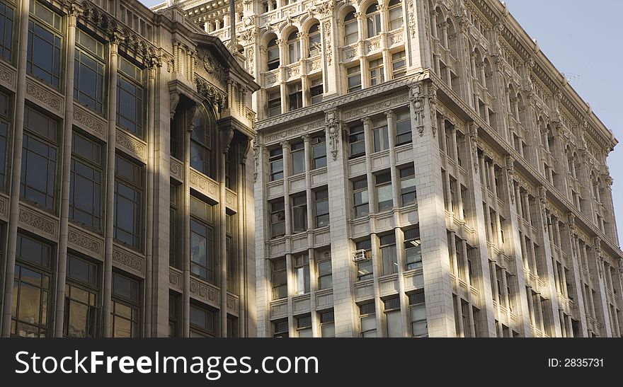 Two older down town buildings at sunrise with light reflections projected from another building. Two older down town buildings at sunrise with light reflections projected from another building.