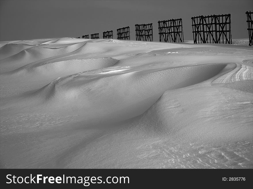 Perspective, snow desert and fence disappearing behind the horizon
