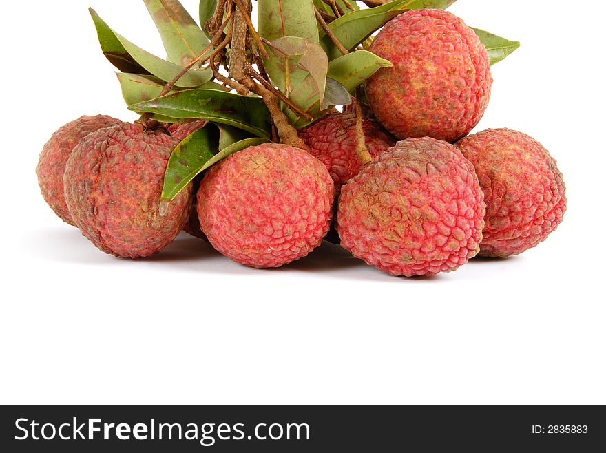 A bunch of lychee with leaves hanging over white background. A bunch of lychee with leaves hanging over white background.