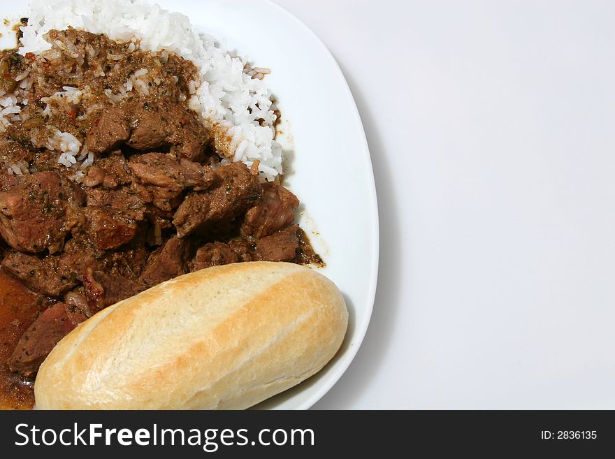 Shot of a plate of stew with bread and rice on white. Shot of a plate of stew with bread and rice on white