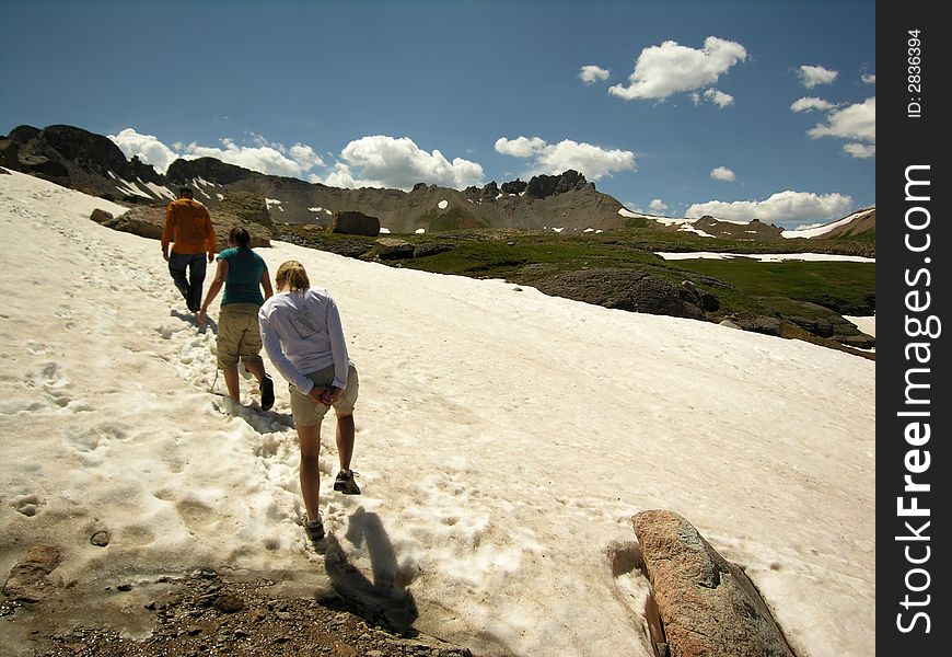 Hikers trek through the snow during the summertime near Silverton, Colorado. Hikers trek through the snow during the summertime near Silverton, Colorado.