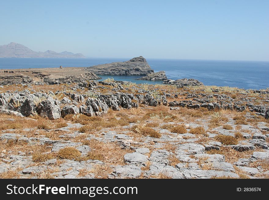 Rocky coastline of ancient city of lindos on the island of rhoads. Rocky coastline of ancient city of lindos on the island of rhoads