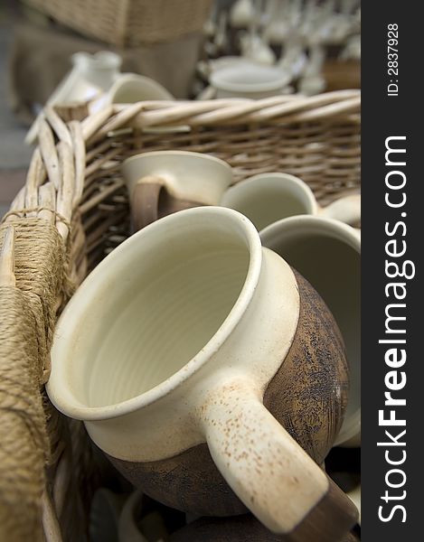 Ceramic handmade cups in the basket on the countryside market