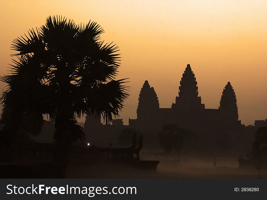 Angkor wat sunrise in silhouette with mist.