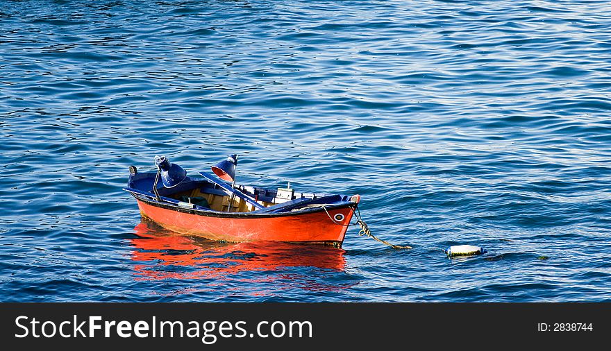 Red fishing boat contrasts with the blue sea. Red fishing boat contrasts with the blue sea