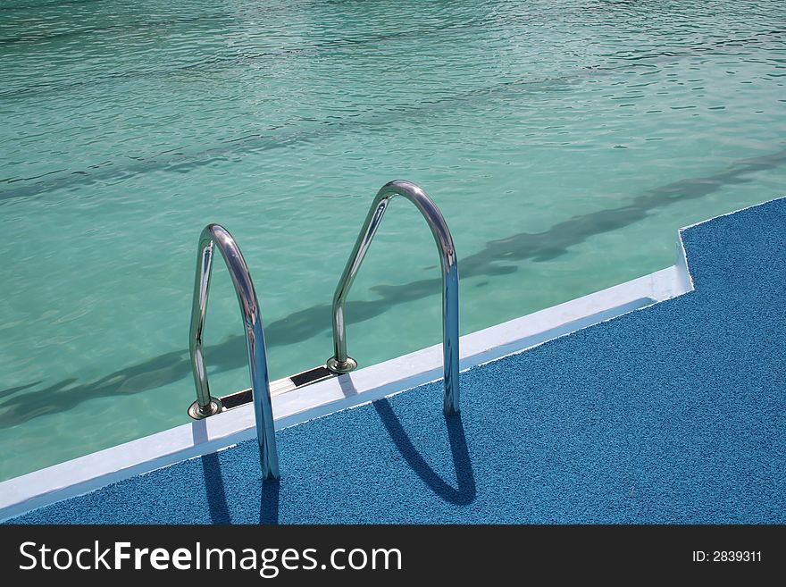 Metal chromeplated ladder in open pool. Metal chromeplated ladder in open pool