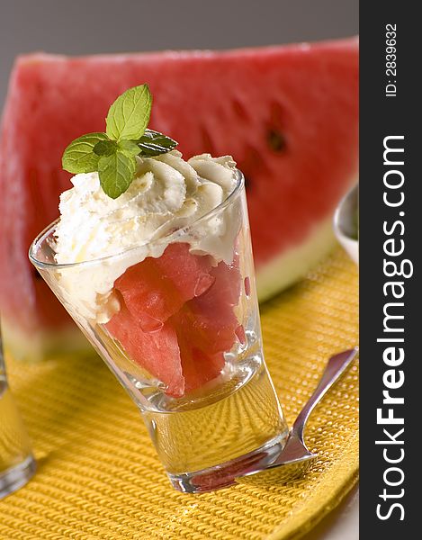 Watermelon in glass with cream close up