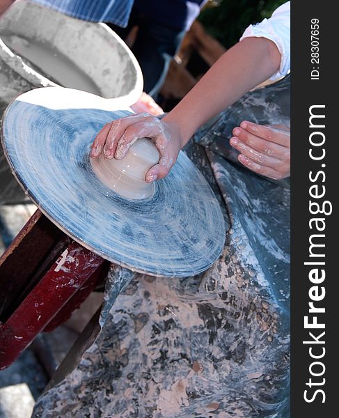 Hand of the child make the product from the clay on the potter's wheel. Hand of the child make the product from the clay on the potter's wheel