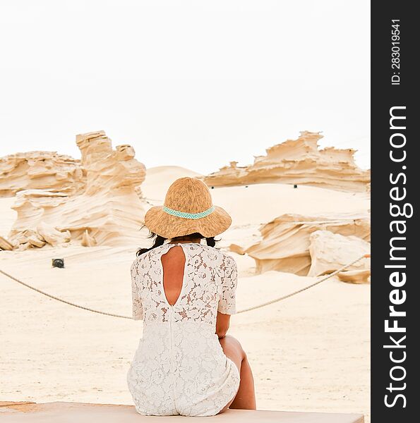 Female tourist visit sit on bench look at Fossil Dunes Structures. Abu Dhabi, UAE. Famous travel destination outside capitsl