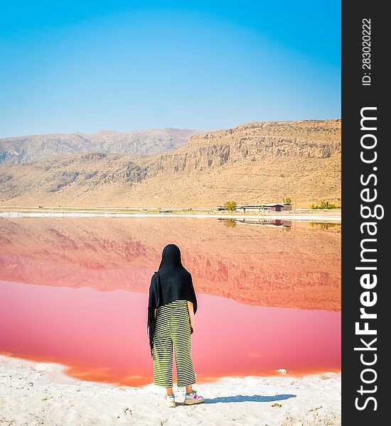 Caucasian woman watch Maharlu pink salt lake panorama in Shiraz, Iran