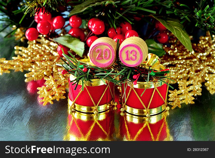 An image of wooden bingo kegs with numbers of coming new year against branch of christmas tree