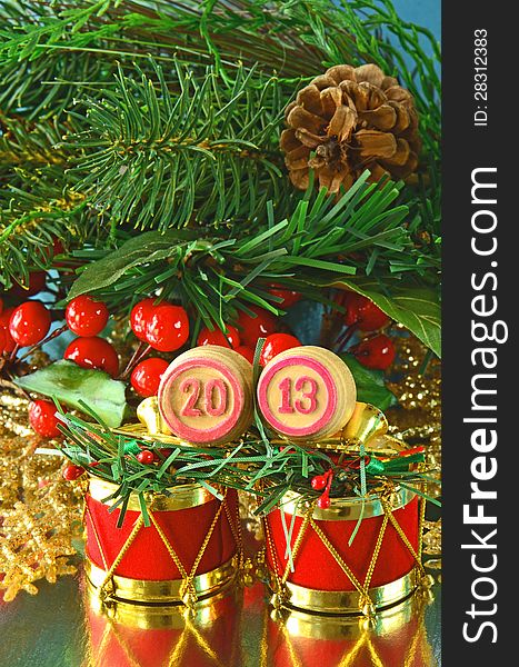 An image of wooden bingo kegs with numbers of coming new year against branch of christmas tree