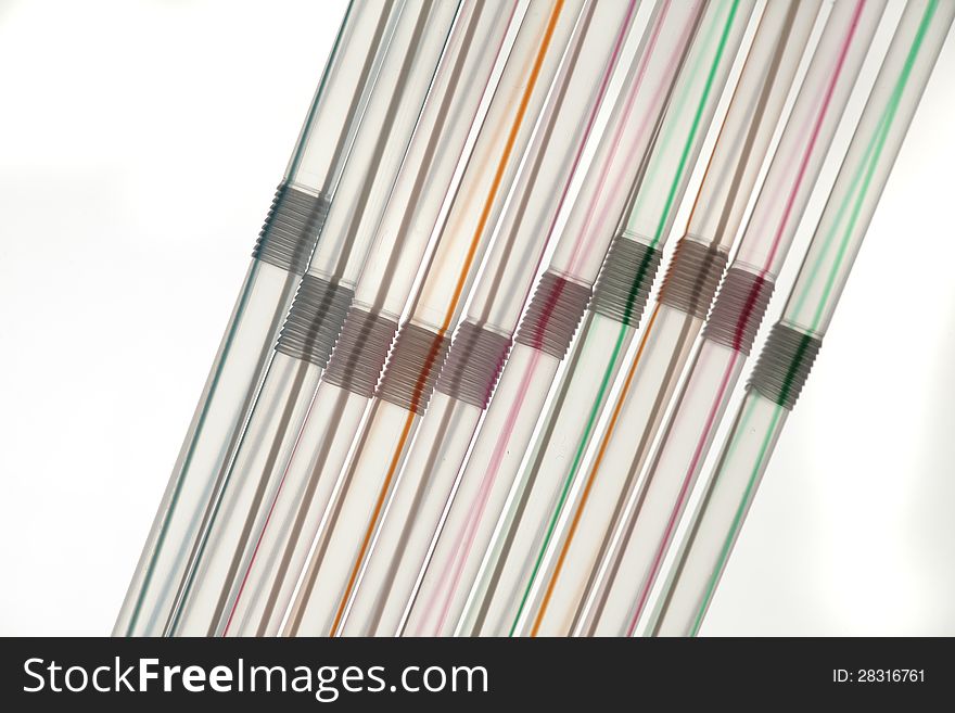 Multicolored tubes for beverage on white background