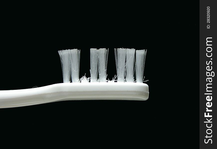 The head of a white toothbrush with gaps. The head of a white toothbrush with gaps