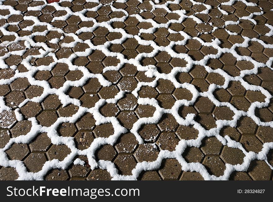 Hexagonal paving slabs covered with snow snaking line. Hexagonal paving slabs covered with snow snaking line