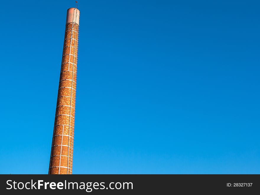 Factory plant industry chimney with clear blue sky behind - Industry background image