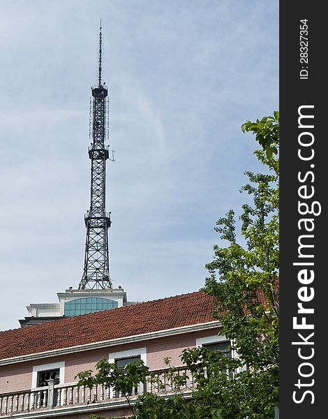 A signal tower behind a building