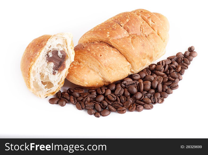 Croissant with coffe beans on white background.