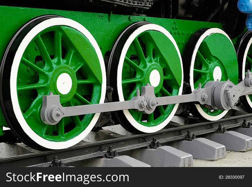 Green wheels of a vintage steam locomotive close-up - horizontal orientation. Green wheels of a vintage steam locomotive close-up - horizontal orientation