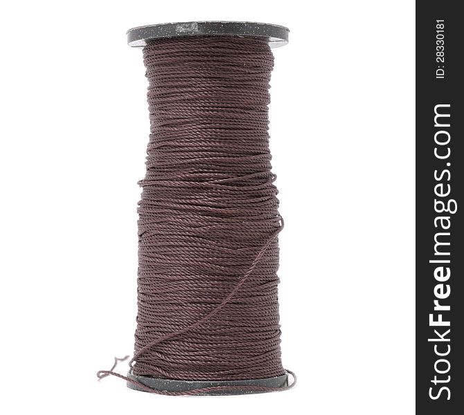 A spool of thick brown capron thread on a white background - square image. A spool of thick brown capron thread on a white background - square image