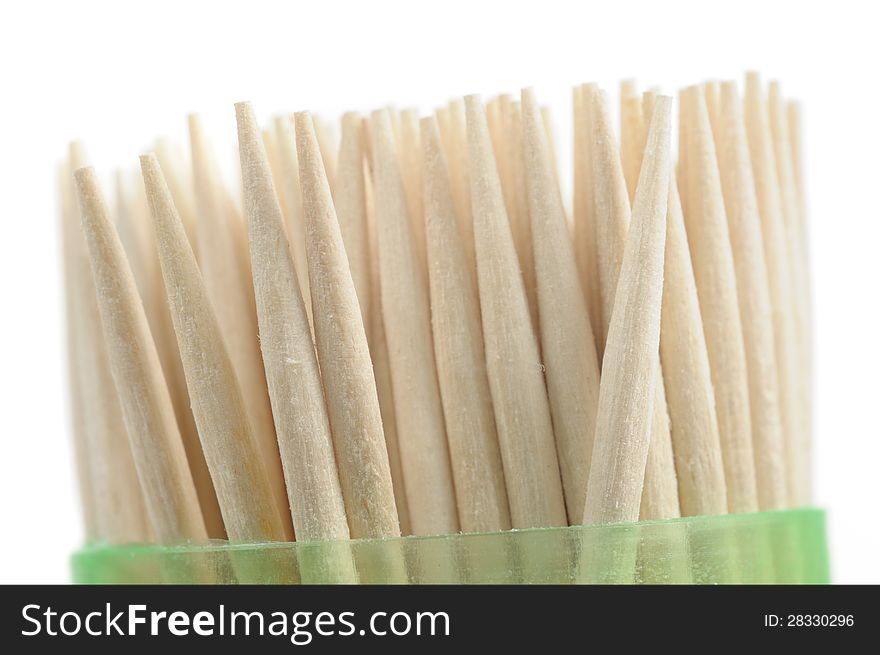 A set of wooden toothpicks in a plastic container on white background. A set of wooden toothpicks in a plastic container on white background