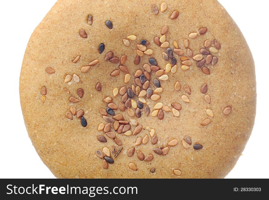 A close-up of whole-wheat bun with tan sesame seeds. A close-up of whole-wheat bun with tan sesame seeds