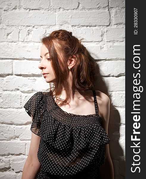 Portrait of Young Woman Looking Away on white brick background