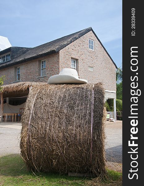 A bale of hay and farmhouse in background. A bale of hay and farmhouse in background